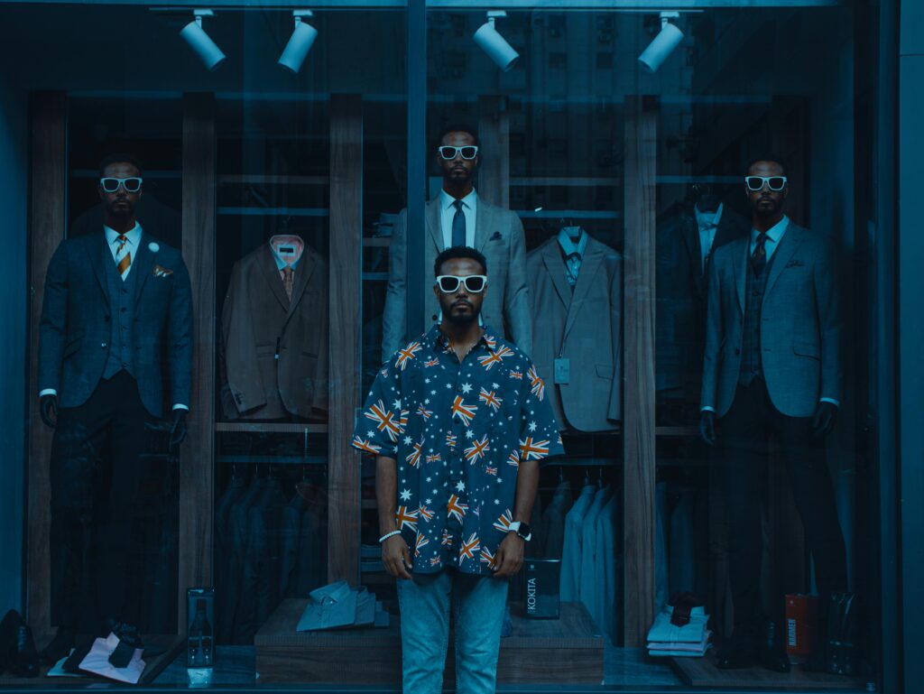 Fashion-forward men in sunglasses showcase suits in a chic London boutique display.